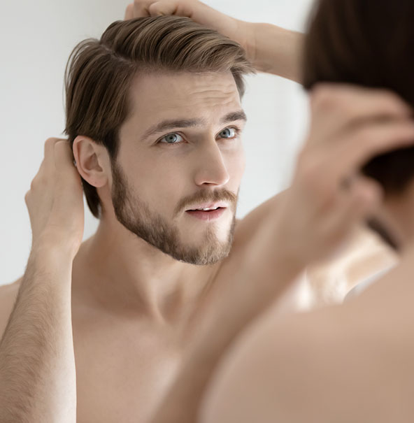 Man fixing his hair in mirror