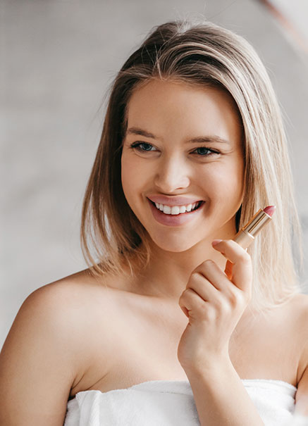 Woman putting lipstick on