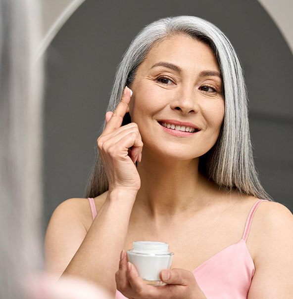 Woman applying face lotion